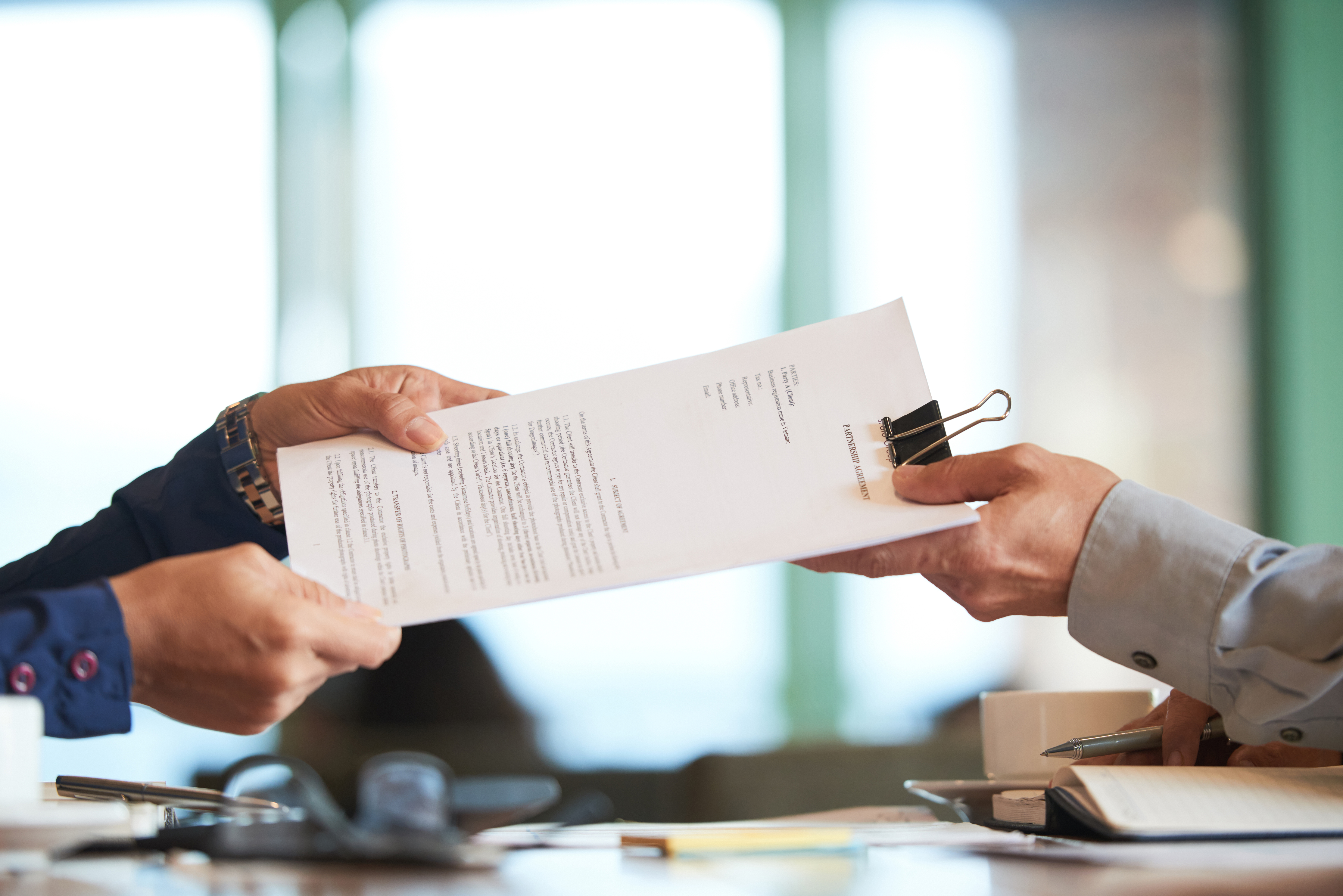 Business person giving partnership agreement to a Coworker